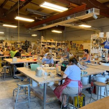 Woman sculpting clay in studio